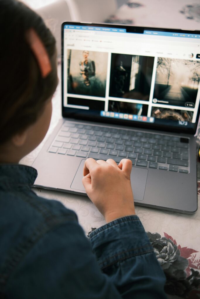 A child looks at photography images on a laptop, exploring stock photos.